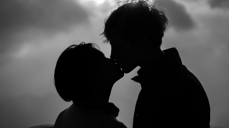 Silhouetten von zwei Menschen, die sich küssen
