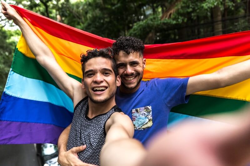 Selfie von zwei Männern mit einer Gay-Pride-Flagge